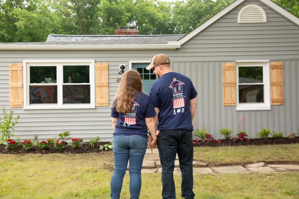 image of Dillon and Keslie standing in front of their home after the home makeover