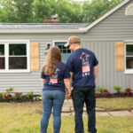image of Dillon and Keslie standing in front of their home after the home makeover