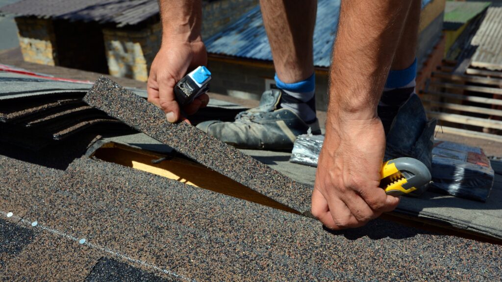 Man working on roof shingles