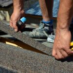 Man working on roof shingles